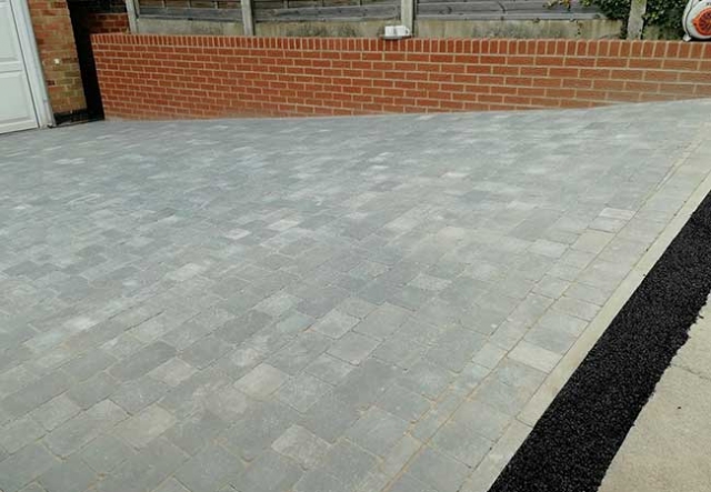 A concrete driveway uplifted, groundwork prepared and a bradstone woburn rumbled graphite pavior in three different sizes laid at a job in Carlton, Nottingham
