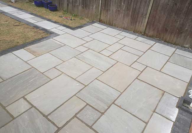 A rear patio we created in Radcliffe on Trent (Nottinghamshire) using a charcoal pavior border with a kandla grey indian sandstone. We also turfed the grassed area.